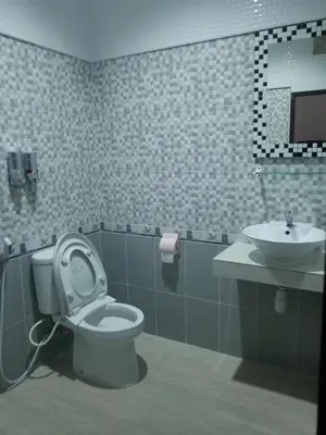 a bathroom with a toilet and a sink at Jepun Segara Guest House in Kuta