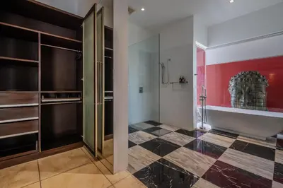 a dressing room with a glass door and a red wall at Villa Samudra Raya in Seminyak