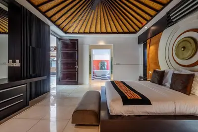 a bedroom with a large bed with a wooden ceiling at Villa Samudra Raya in Seminyak