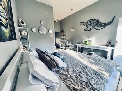 a bedroom with a large bed and a desk at Gladstudio in Kerobokan