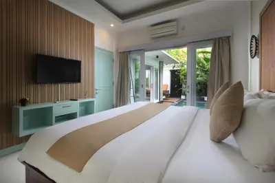 a large bedroom with a large white bed and a television at Zowa Villa Seminyak byFaba in Seminyak