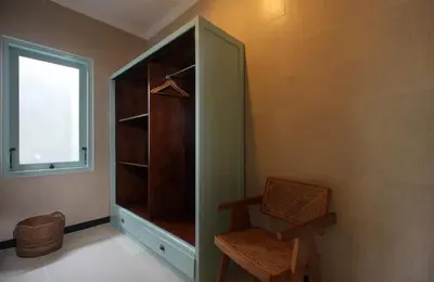 a green closet with a chair and a window at Zowa Villa Seminyak byFaba in Seminyak