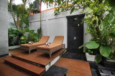 a patio with two chairs and some plants at Zowa Villa Seminyak byFaba in Seminyak