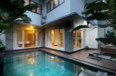 a house with a swimming pool in front of a house at Zowa Villa Seminyak byFaba in Seminyak