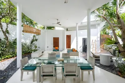 a dining room with a glass table and chairs at Modern 2BR Villa with Private Pool Prime Location in Seminyak
