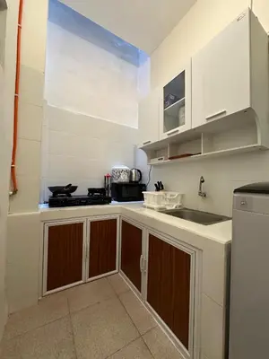 a kitchen with white cabinets and a sink at Rumah Jimbaran Kuta 2 bedroom 6 pax SukaBali 2 in Jimbaran