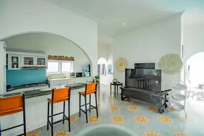 a kitchen with a stove and a kitchen with orange bar stools at villa putih in Seminyak