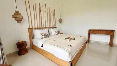 a bedroom with a bed with a wooden headboard at Villa Bumbabu in Kerobokan