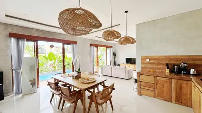 a kitchen with a table and chairs in a room at Villa Bumbabu in Kerobokan