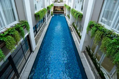 an aisle between two buildings with blue water in the middle at Grand Inkuta in Seminyak