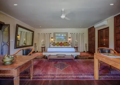a bedroom with a bed and a table and chairs at Villa Mata Budha Seminyak in Seminyak