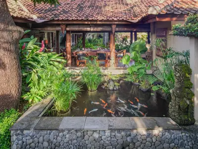 a garden with a koi pond in front of a house at Villa Mata Budha Seminyak in Seminyak