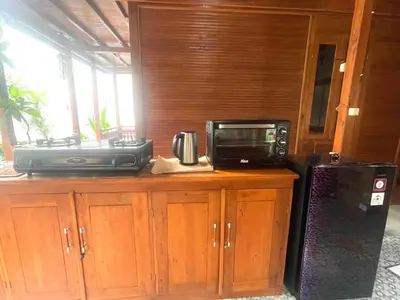 a microwave sitting on top of a counter next to a refrigerator at 2BR Abelle garden lumbung house in Kerobokan