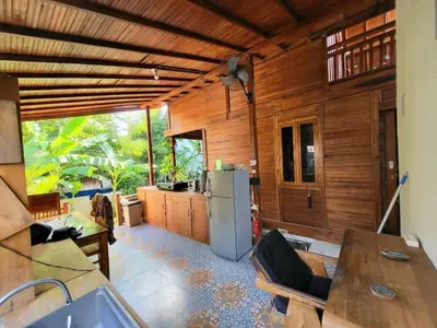 a kitchen with wooden walls and a refrigerator at 2BR Abelle garden lumbung house in Kerobokan