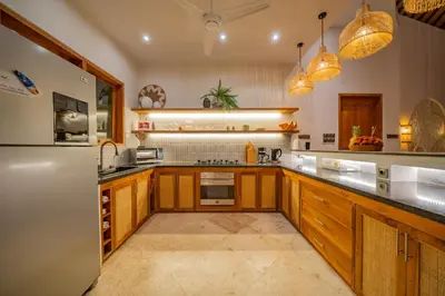 a large kitchen with wooden cabinets and a refrigerator at Villa Lea Luxury Oasis in Seminyak Umalas with private pool 4BR in Seminyak