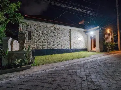 a building with a brick walkway in front of it at night at Metta Villa in Jimbaran