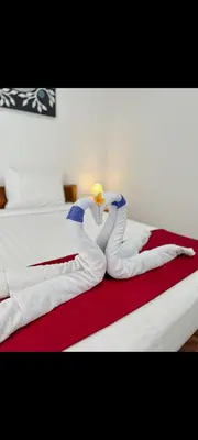 two swans made out of towels on a bed at narayuka house kamar 3 in Seminyak