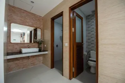 a bathroom with a sink and a toilet and a mirror at Pepitu Dormitory By Sandat in Kuta