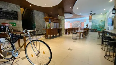 a bike parked in a restaurant with tables and chairs at Pepitu Dormitory By Sandat in Kuta