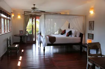 a bedroom with a bed with a mosquito net at Villa Varuna in Legian