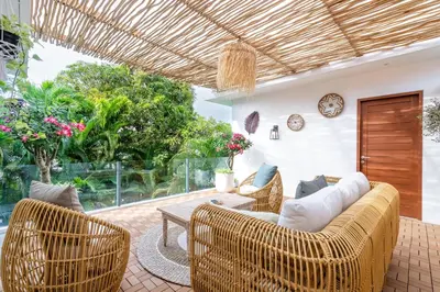 a living room with wicker chairs and a couch at Villa Arbolita by JB Villas in Seminyak