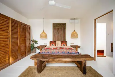 a bedroom with a wooden bed and a wooden wall at Villa Galanga - Brand New Ethnic Hacienda Villa Next to Canggu with Private Pool and Parking in Kerobokan