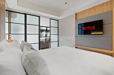 a bedroom with a bed and a tv on the wall at Palma by Kozystay - Nusa Dua in Nusa Dua