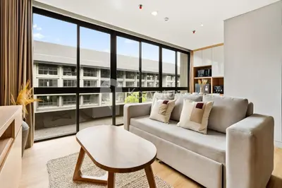 a living room with a couch and a large window at Palma by Kozystay - Nusa Dua in Nusa Dua