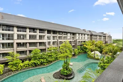 an apartment building with a pool in front of it at Palma by Kozystay - Nusa Dua in Nusa Dua