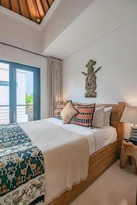 a bedroom with a large bed and a window at Sister Suites in Seminyak