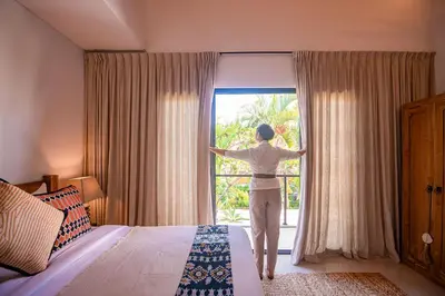 a woman is looking out of a window at Sister Suites in Seminyak