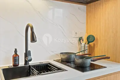 a kitchen counter with two pots on a stove at Olaia by Kozystay - Nusa Dua in Nusa Dua
