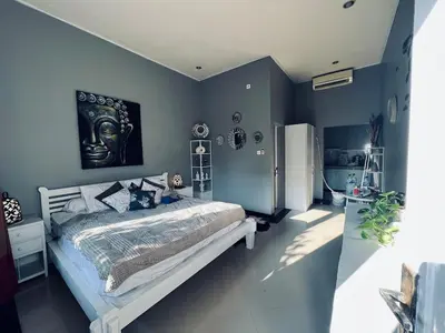 a bedroom with a large bed with blue walls at Gladstudio BrandNew in Kerobokan
