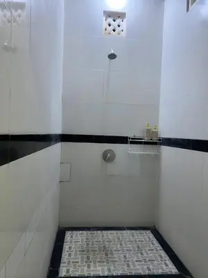 a bathroom with a shower with black and white tiles at Gladstudio BrandNew in Kerobokan