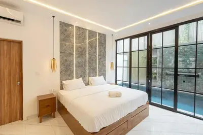 a bedroom with a large bed and a large window at Cozy Seminyak Loft 360 in Seminyak