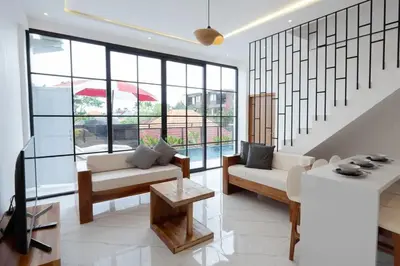 a living room with white furniture and large windows at Cozy Seminyak Loft 360 in Seminyak