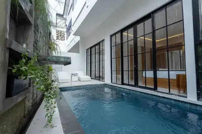a swimming pool in the middle of a building at Cozy Seminyak Loft 360 in Seminyak
