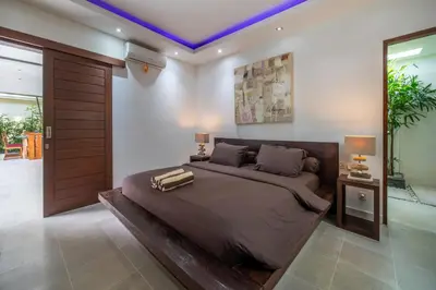 a bedroom with a large bed and two lamps at Villa Minha Gente Seminyak in Seminyak