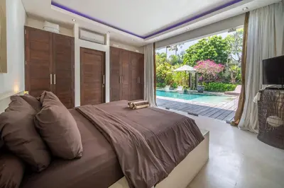 a bedroom with a large bed and a large window at Villa Minha Gente Seminyak in Seminyak