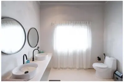 a bathroom with a sink and a toilet and a mirror at Villa Hari in Seminyak