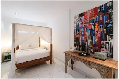 a bedroom with a bed and a painting on the wall at Villa Hari in Seminyak