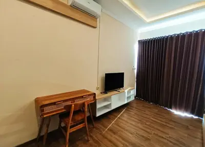 a living room with a desk and a television and a table at Room Hangtuah Sanur in Kuta