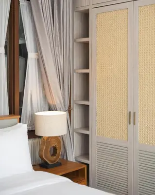 a bedroom with a bed and a book shelf at The Mango Villa Jimbaran Jimbaran in Jimbaran