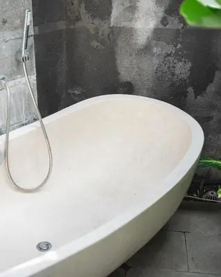 a white bath tub sitting in a bathroom at The Mango Villa Jimbaran Jimbaran in Jimbaran