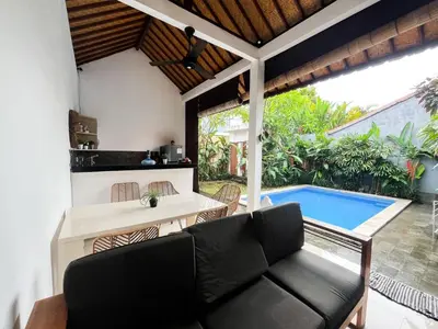 a living room with a couch and a swimming pool at Villa Sayang 2 in Seminyak