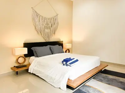 a bedroom with a large white bed and a chandelier at Villa Sayang 2 in Seminyak