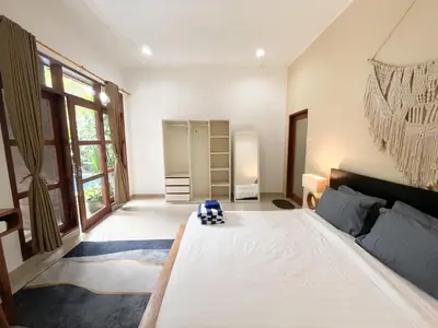 a bedroom with a large white bed in a room at Villa Sayang 2 in Seminyak