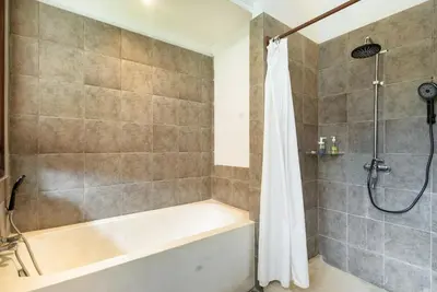 a bathroom with a tub and a shower at Lacita Villa Seminyak in Seminyak