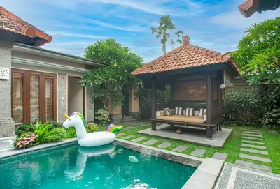 a swimming pool with a swan and a house at Lacita Villa Seminyak in Seminyak