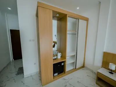 a room with a wooden closet with a mirror at Pachira Living Legian in Legian